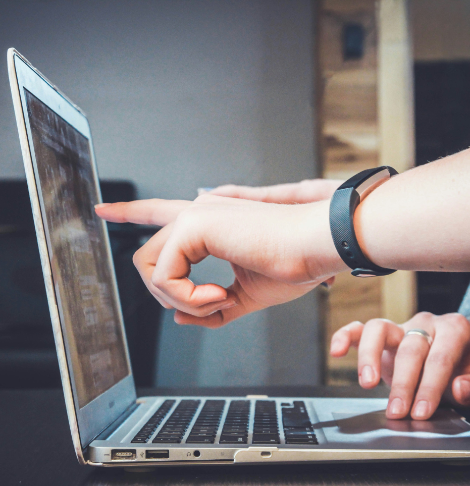 Two hands pointing to a laptop screen